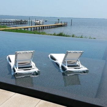 Infinity pool with sun shelf and deck chairs